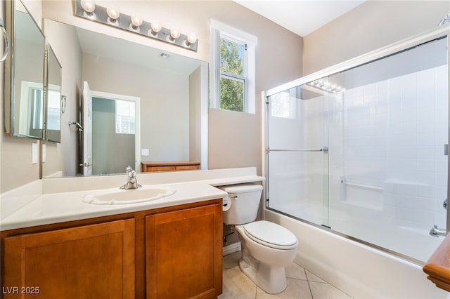 bathroom featuring tile patterned flooring, combined bath / shower with glass door, toilet, and vanity