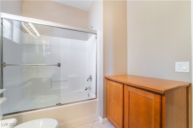 bathroom featuring tile patterned flooring, toilet, and bath / shower combo with glass door