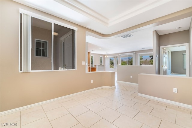 empty room with light tile patterned floors, visible vents, and baseboards