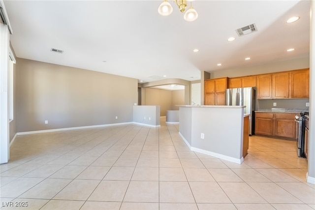 kitchen with open floor plan, light tile patterned floors, visible vents, and appliances with stainless steel finishes