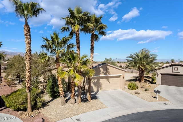 4963 Pensier St, Las Vegas, NV 89135 - view of property hidden behind natural elements featuring concrete driveway, stucco siding, a garage, and a mountain view