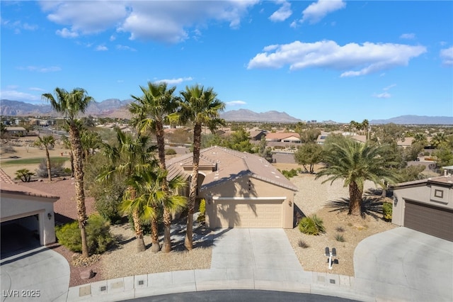 view of front of property featuring an attached garage, stucco siding, concrete driveway, a tile roof, and a mountain view