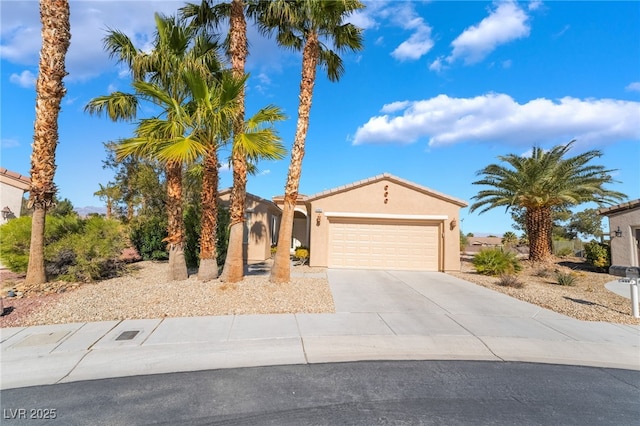 mediterranean / spanish house featuring stucco siding, a garage, and driveway