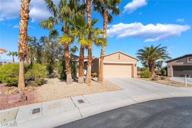 mediterranean / spanish house featuring an attached garage, driveway, and stucco siding