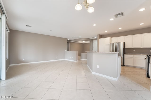 4963 Pensier St, Las Vegas, NV 89135 - kitchen featuring freestanding refrigerator, open floor plan, visible vents, and white cabinets