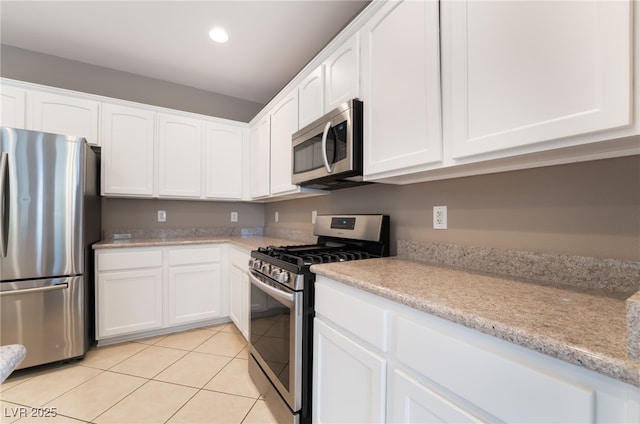 4963 Pensier St, Las Vegas, NV 89135 - kitchen with stainless steel appliances, recessed lighting, white cabinetry, light tile patterned floors, and light stone countertops