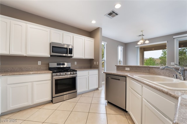 4963 Pensier St, Las Vegas, NV 89135 - kitchen with light tile patterned floors, a sink, stainless steel appliances, white cabinetry, and visible vents