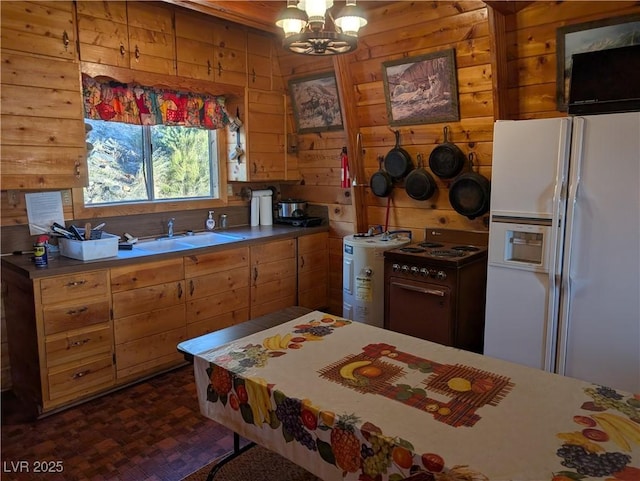 kitchen with a notable chandelier, a sink, range with electric stovetop, white refrigerator with ice dispenser, and wood walls