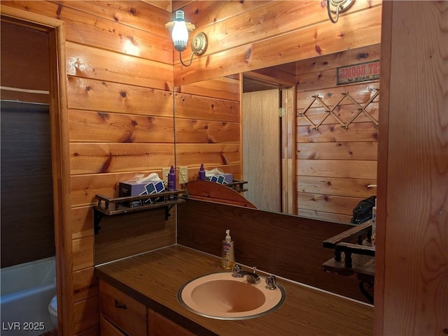 bathroom with vanity, toilet, and wood walls