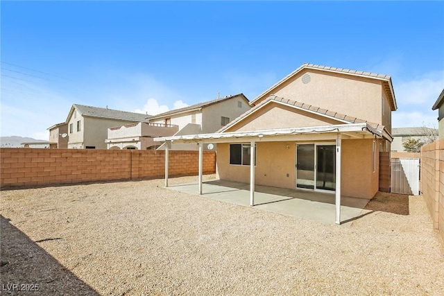 back of house with stucco siding, a fenced backyard, and a patio area