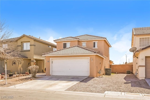 view of front of home with fence, a tile roof, concrete driveway, stucco siding, and an attached garage