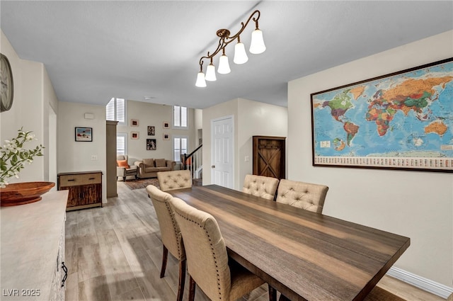 dining room featuring stairs and light wood-type flooring