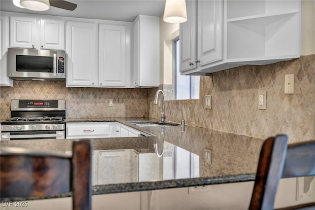 kitchen with a sink, open shelves, stainless steel appliances, white cabinets, and decorative backsplash