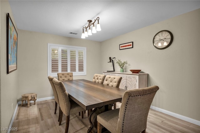 dining room featuring light wood-style flooring, baseboards, and visible vents