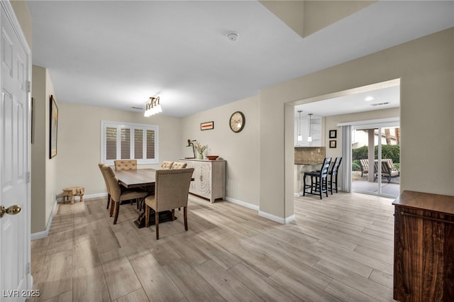 dining space with baseboards and light wood-style floors