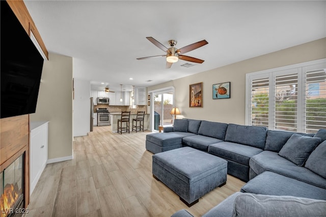 living area featuring visible vents, a ceiling fan, recessed lighting, light wood finished floors, and baseboards