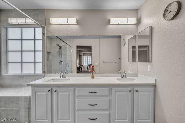 ensuite bathroom featuring double vanity, a stall shower, ensuite bathroom, and a sink