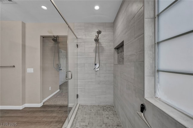 bathroom featuring visible vents, baseboards, recessed lighting, a stall shower, and wood finished floors