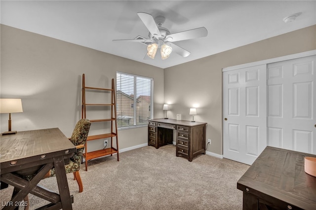 office space with light colored carpet, baseboards, and ceiling fan