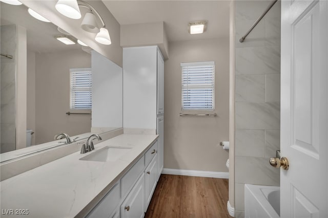 full bathroom featuring baseboards, toilet, shower / bathtub combination, wood finished floors, and vanity