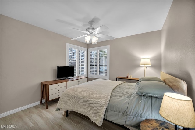 bedroom featuring a ceiling fan, baseboards, and wood finished floors