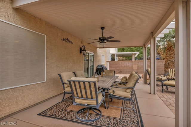 view of patio with outdoor dining area, fence, and ceiling fan