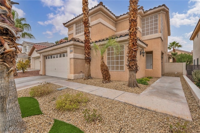 mediterranean / spanish-style home with fence, a tile roof, stucco siding, a garage, and driveway