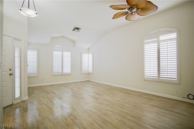 unfurnished room featuring a wealth of natural light, lofted ceiling, ceiling fan, and wood finished floors