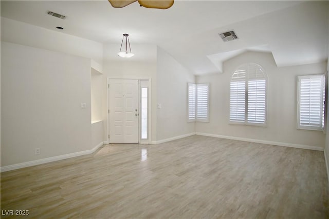 foyer entrance featuring light wood-style floors, a ceiling fan, visible vents, and lofted ceiling