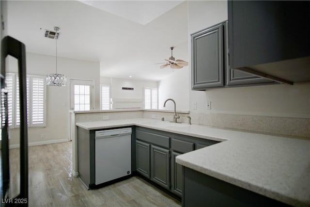 kitchen featuring gray cabinets, ceiling fan with notable chandelier, a sink, a peninsula, and white dishwasher