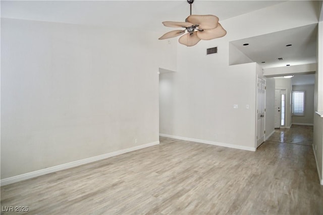 empty room featuring visible vents, baseboards, light wood-style floors, and ceiling fan