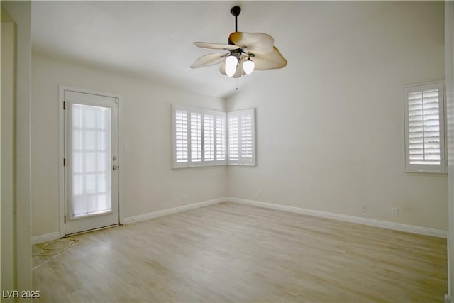 unfurnished room featuring a wealth of natural light, baseboards, a ceiling fan, and wood finished floors