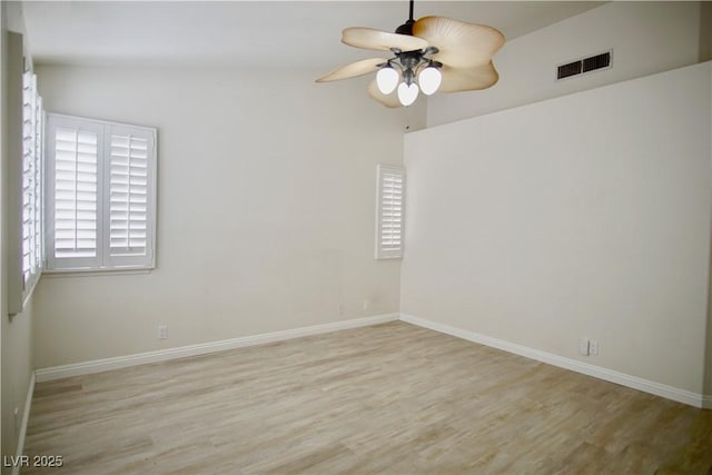 unfurnished room with wood finished floors, a ceiling fan, visible vents, and baseboards