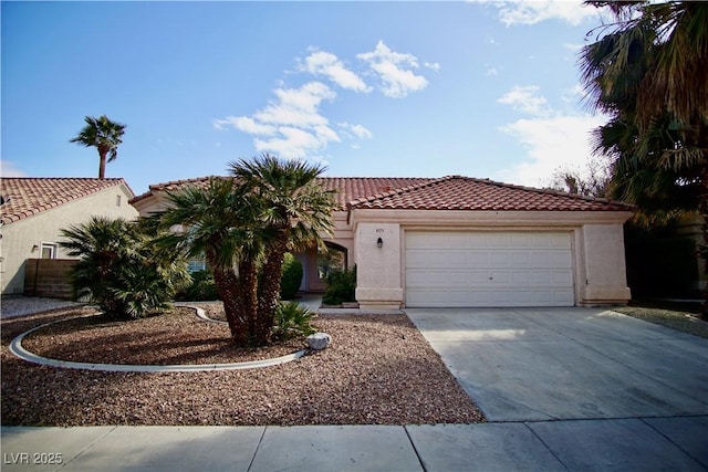 mediterranean / spanish-style house featuring a tile roof, an attached garage, concrete driveway, and stucco siding