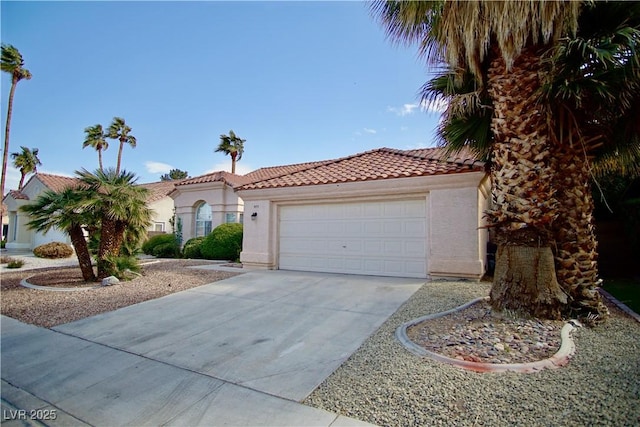 mediterranean / spanish-style house with a garage, stucco siding, driveway, and a tiled roof