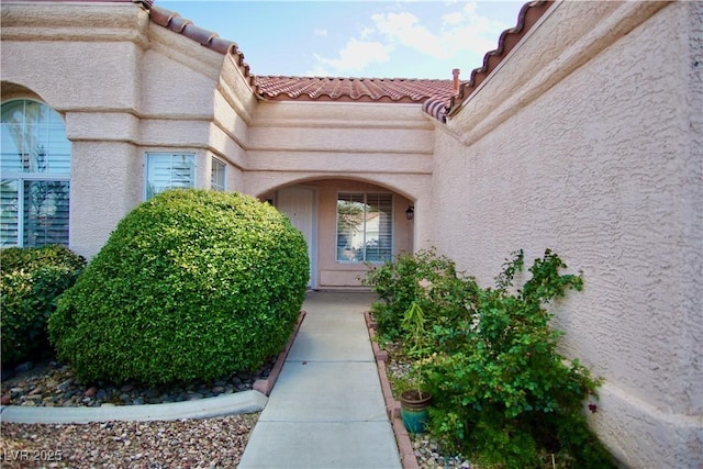 property entrance featuring stucco siding and a tiled roof