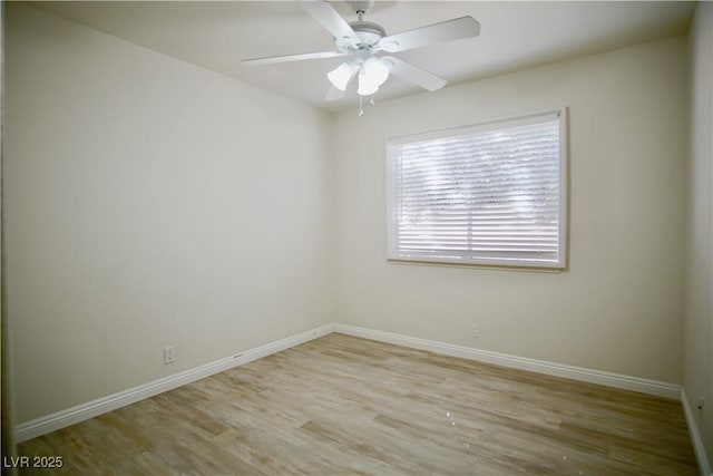 spare room featuring baseboards, wood finished floors, and a ceiling fan