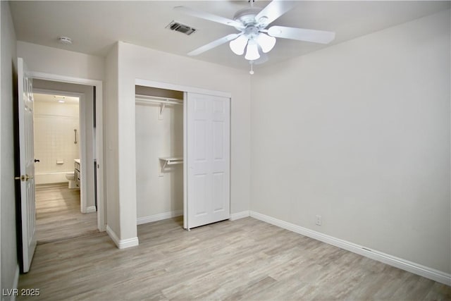 unfurnished bedroom with light wood finished floors, visible vents, baseboards, and a closet