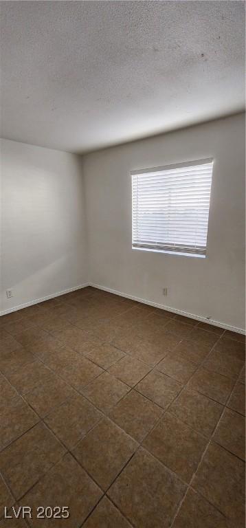 510 Holick Ave, Henderson, NV 89011 - empty room featuring a textured ceiling and dark tile patterned flooring