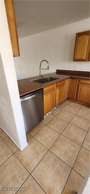 510 Holick Ave, Henderson, NV 89011 - kitchen featuring stainless steel dishwasher, dark countertops, brown cabinetry, and light tile patterned floors