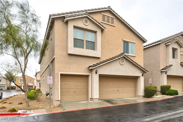 view of front of home with stucco siding, an attached garage, and a tile roof