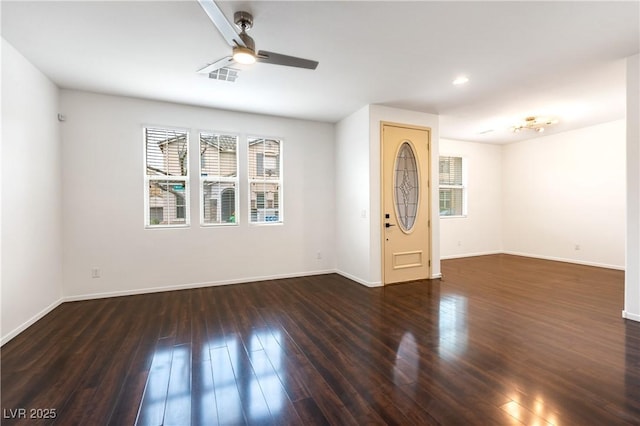 interior space with hardwood / wood-style flooring, baseboards, visible vents, and ceiling fan