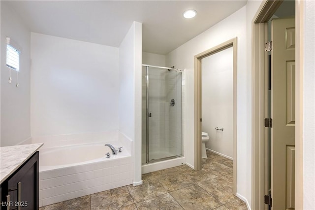 bathroom with vanity, toilet, a bath, and a stall shower