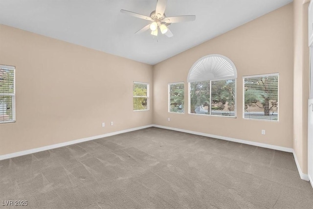 carpeted spare room featuring lofted ceiling, baseboards, and ceiling fan