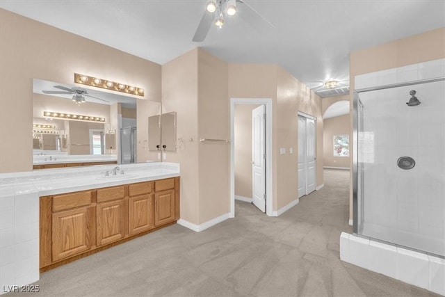 full bathroom featuring vanity, a ceiling fan, baseboards, visible vents, and a shower stall