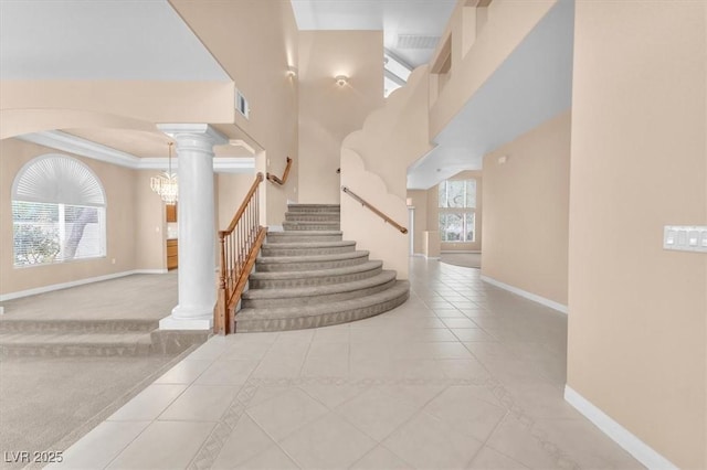 stairway with visible vents, baseboards, decorative columns, crown molding, and tile patterned floors