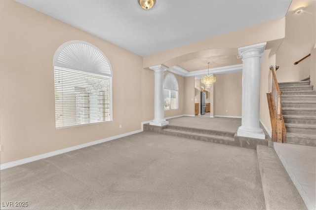 unfurnished living room featuring stairway, decorative columns, carpet, and baseboards