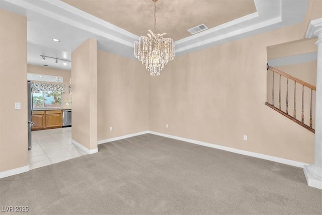 empty room featuring visible vents, light colored carpet, an inviting chandelier, and a tray ceiling