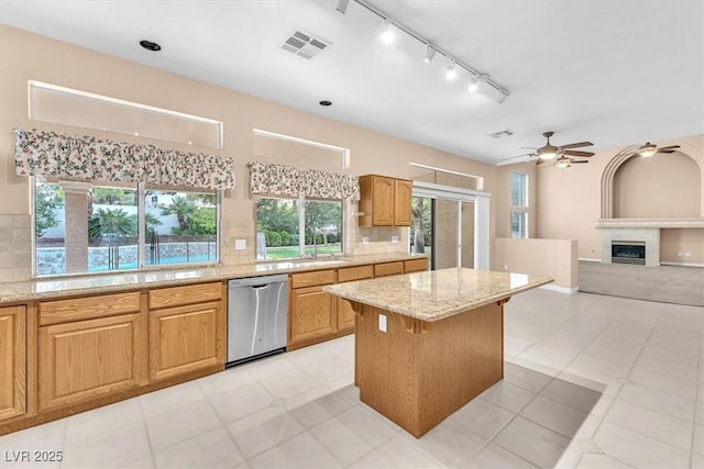 kitchen featuring a ceiling fan, visible vents, dishwasher, tasteful backsplash, and a center island