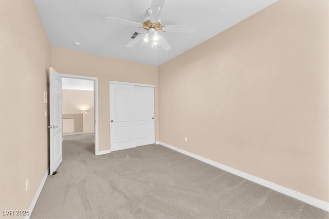 unfurnished bedroom with visible vents, a closet, carpet, baseboards, and ceiling fan